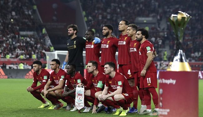Players of Liverpool line up next to the trophy for winners of the Club World Cup final soccer match between Liverpool and Flamengo at Khalifa International Stadium in Doha, Qatar, Saturday, Dec. 21, 2019. (AP Photo/Hassan Ammar)