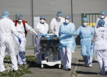 A victim of the Covid-19 virus is evacuated from the Mulhouse civil hospital, eastern France, Monday March 23, 2020. The Grand Est region is now the epicenter of the outbreak in France, which has buried the third most virus victims in Europe, after Italy and Spain. For most people, the new coronavirus causes only mild or moderate symptoms. For some it can cause more severe illness. (AP Photo/Jean-Francois Badias)