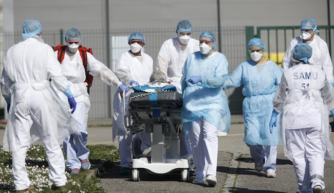 A victim of the Covid-19 virus is evacuated from the Mulhouse civil hospital, eastern France, Monday March 23, 2020. The Grand Est region is now the epicenter of the outbreak in France, which has buried the third most virus victims in Europe, after Italy and Spain. For most people, the new coronavirus causes only mild or moderate symptoms. For some it can cause more severe illness. (AP Photo/Jean-Francois Badias)