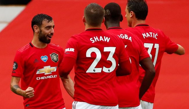 Manchester United's Portuguese midfielder Bruno Fernandes (L) celebrates with teammates after scoring a goal during the English Premier League football match between Manchester United and Bournemouth at Old Trafford in Manchester, north west England, on July 4, 2020. (Photo by Clive Brunskill / POOL / AFP) / RESTRICTED TO EDITORIAL USE. No use with unauthorized audio, video, data, fixture lists, club/league logos or 'live' services. Online in-match use limited to 120 images. An additional 40 images may be used in extra time. No video emulation. Social media in-match use limited to 120 images. An additional 40 images may be used in extra time. No use in betting publications, games or single club/league/player publications. /