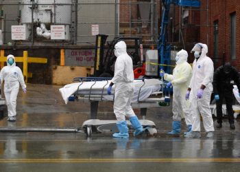 Medical personnel move a deceased patient to a refrigerated truck serving as make shift morgues at Brooklyn Hospital Center on April 09, 2020 in New York City. - America's coronavirus epicenter of New York recorded a new single-day high of 799 COVID-19 deaths Thursday but Governor Andrew Cuomo said the rate of hospitalizations continued to fall. (Photo by Angela Weiss / AFP)