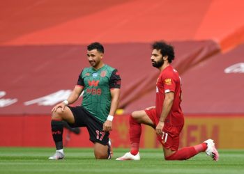Aston Villa's Egyptian midfielder Trezeguet (L) and Liverpool's Egyptian midfielder Mohamed Salah (R) take a knee in support of the Black Lives Movement during the English Premier League football match between Liverpool and Aston Villa at Anfield in Liverpool, north west England on July 5, 2020. (Photo by Paul ELLIS / POOL / AFP) / RESTRICTED TO EDITORIAL USE. No use with unauthorized audio, video, data, fixture lists, club/league logos or 'live' services. Online in-match use limited to 120 images. An additional 40 images may be used in extra time. No video emulation. Social media in-match use limited to 120 images. An additional 40 images may be used in extra time. No use in betting publications, games or single club/league/player publications. /