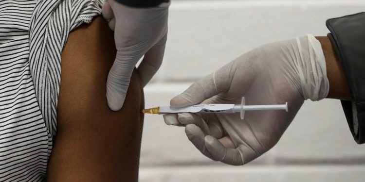 A volunteer receives an injection from a medical worker during the country's first human clinical trial for a potential vaccine against the novel coronavirus, at the Baragwanath hospital in Soweto, South Africa, June 24, 2020. REUTERS/Siphiwe Sibeko