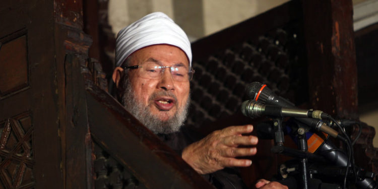 Egyptian Muslim scholar Sheikh Yusuf al-Qaradawi addresses Muslims at Al-Azhar mosque during the weekly Friday prayer in Cairo on December 28, 2012. People demonstrated outside the Al-Azhar mosque in support of the Syrian people and against Syria's President Bashar al-Assad.  AFP PHOTO/MAHMUD HAMS (Photo by MAHMUD HAMS / AFP)